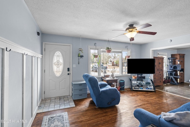 living area with a textured ceiling, wood finished floors, and a ceiling fan