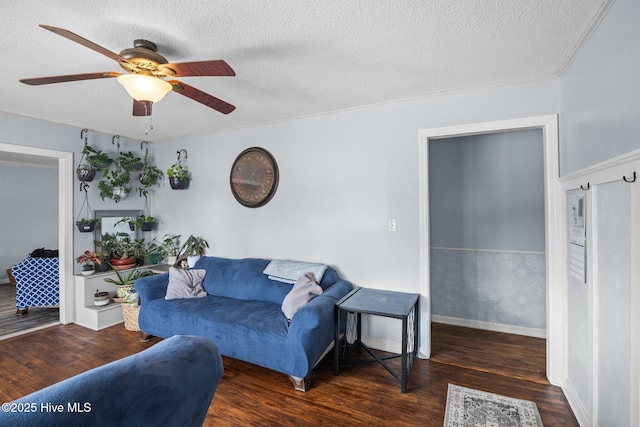 living area with a textured ceiling, wood finished floors, a ceiling fan, and baseboards