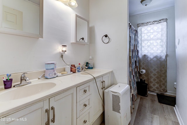 full bathroom with double vanity, wood finished floors, a sink, and a shower with shower curtain