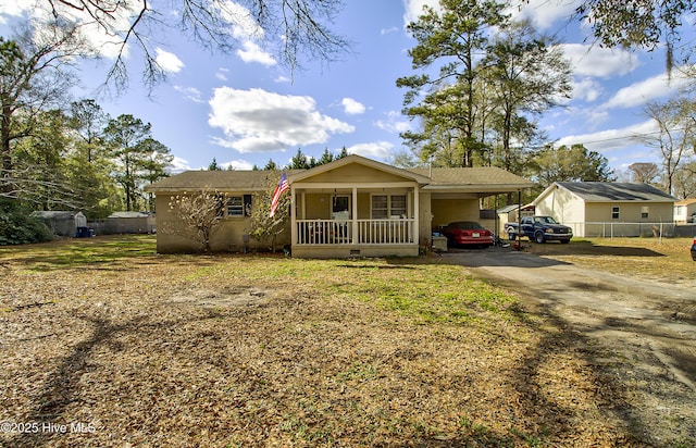 view of front of house with driveway, crawl space, covered porch, a front lawn, and a carport