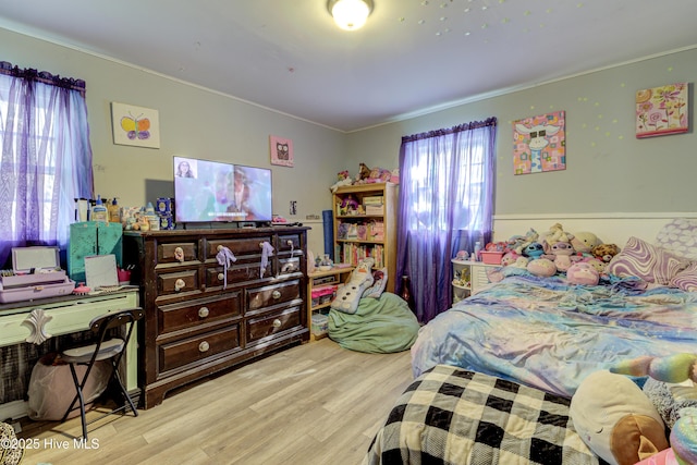 bedroom with multiple windows and wood finished floors