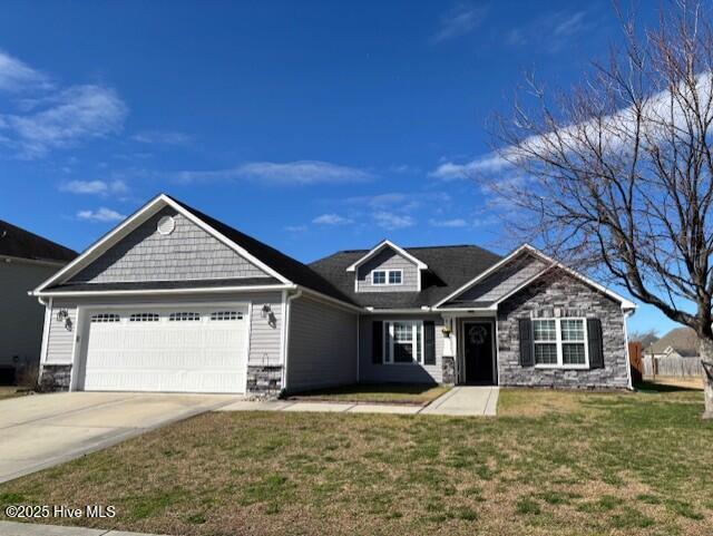 craftsman house featuring a garage, stone siding, driveway, and a front lawn