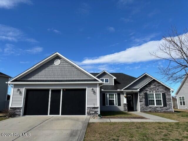 craftsman-style house featuring a garage, stone siding, a front lawn, and concrete driveway