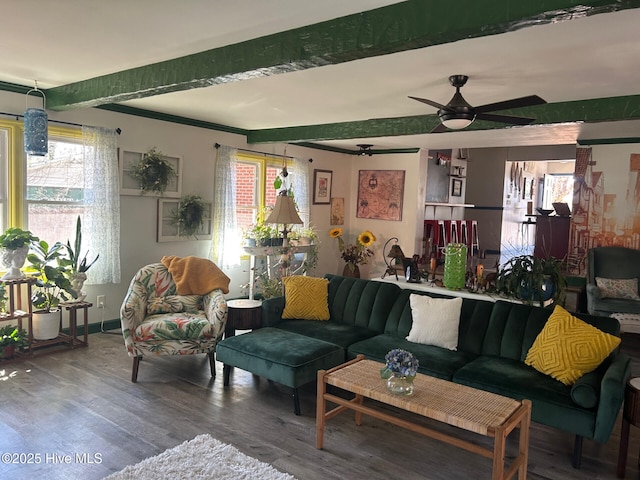 living area with baseboards, a ceiling fan, beamed ceiling, and wood finished floors