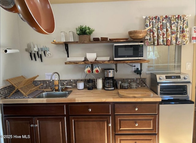 kitchen featuring dark brown cabinets, open shelves, and a sink