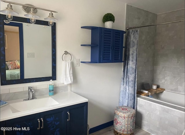 ensuite bathroom featuring tiled shower / bath combo, ensuite bath, and vanity