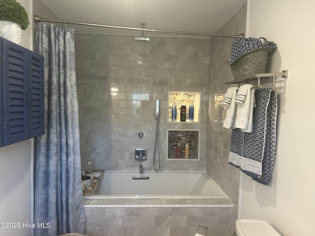 full bathroom featuring tiled shower / bath and toilet