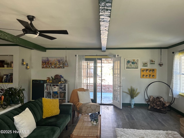 living room with plenty of natural light, wood finished floors, beam ceiling, and a ceiling fan