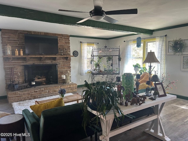 living area featuring beamed ceiling, a fireplace, and a wealth of natural light