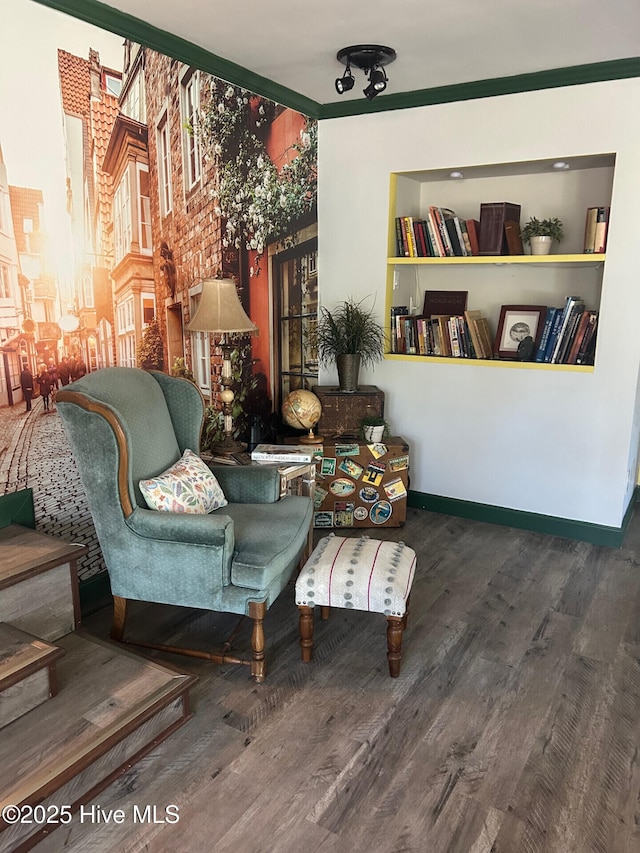 living area with built in shelves, wood finished floors, and baseboards