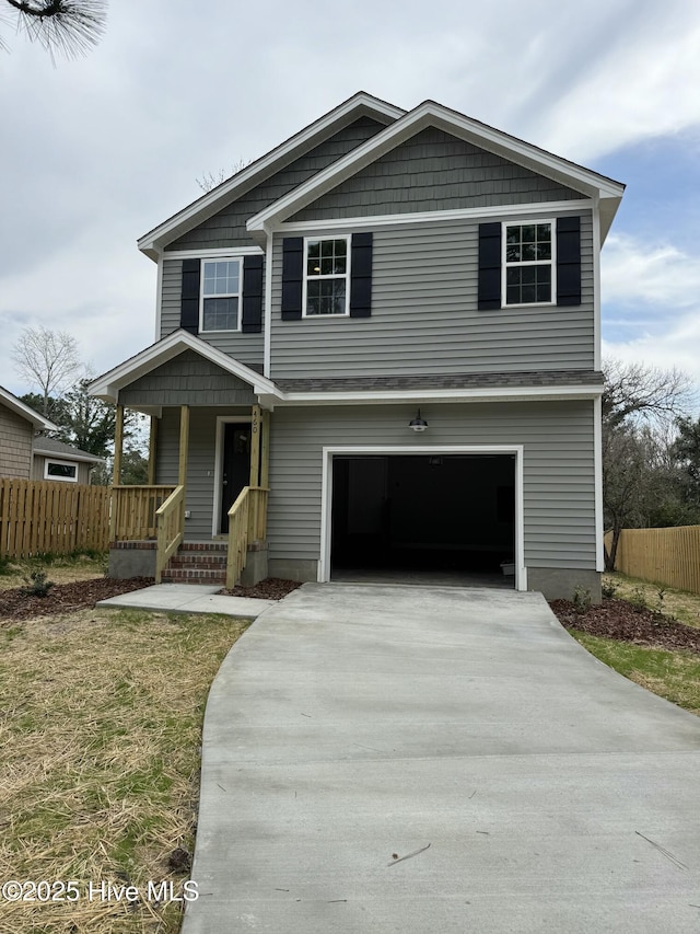 traditional-style home featuring covered porch, an attached garage, driveway, and fence