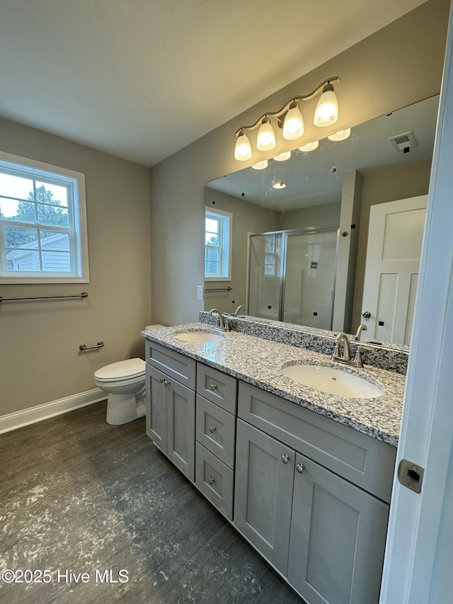 bathroom with a sink, baseboards, a stall shower, and wood finished floors