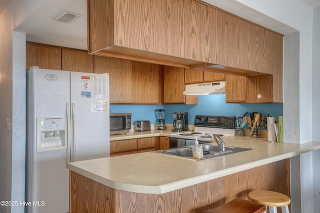 918 N New River Dr Unit 728, Surf City, NC 28445 - kitchen with white fridge with ice dispenser, a peninsula, under cabinet range hood, stainless steel microwave, and electric stove
