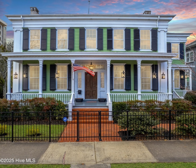 view of front of property with a fenced front yard and covered porch