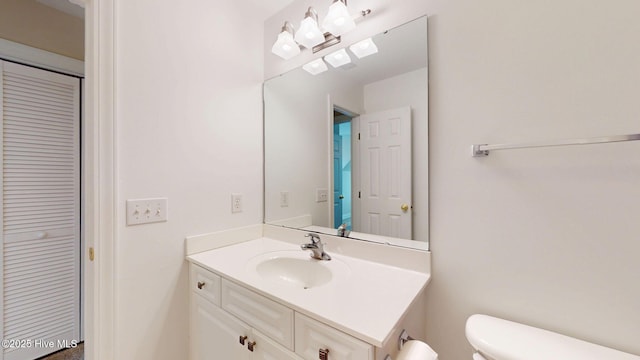 bathroom with toilet, a closet, and vanity