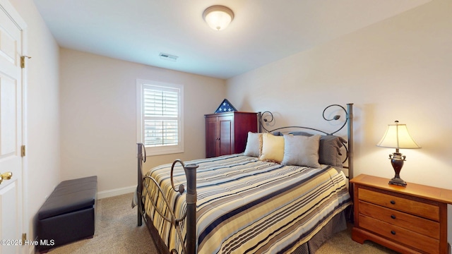 carpeted bedroom with visible vents and baseboards