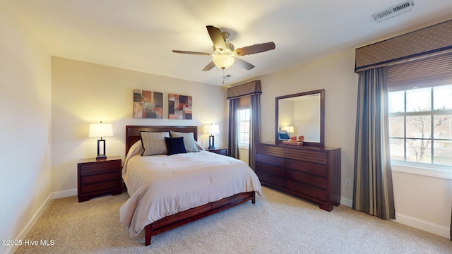 carpeted bedroom with a ceiling fan, visible vents, and baseboards