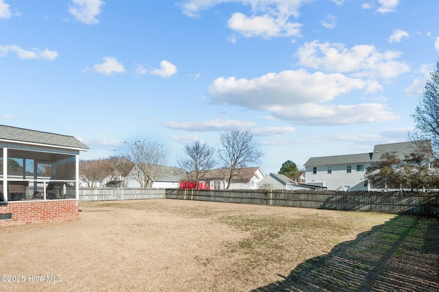 view of yard featuring a sunroom and a fenced backyard