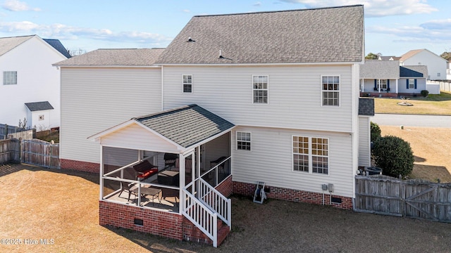 rear view of house featuring a lawn, a sunroom, a fenced backyard, roof with shingles, and crawl space