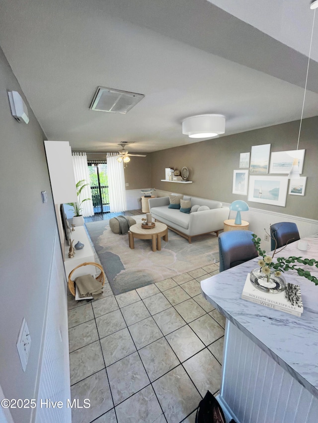 living area featuring ceiling fan and light tile patterned flooring