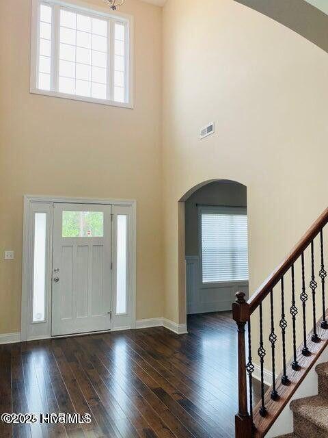 foyer featuring stairs, a high ceiling, wood-type flooring, and baseboards