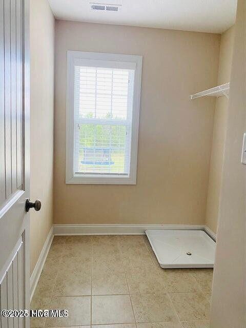 laundry room with light tile patterned flooring, visible vents, and baseboards