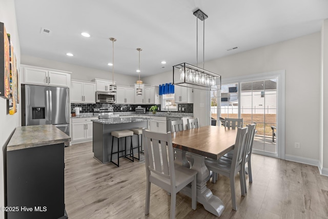 dining area featuring light wood-style flooring, visible vents, and recessed lighting