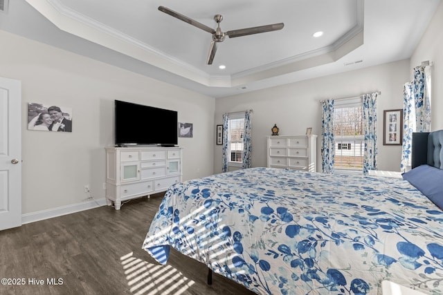 bedroom with dark wood-type flooring, a raised ceiling, multiple windows, and crown molding