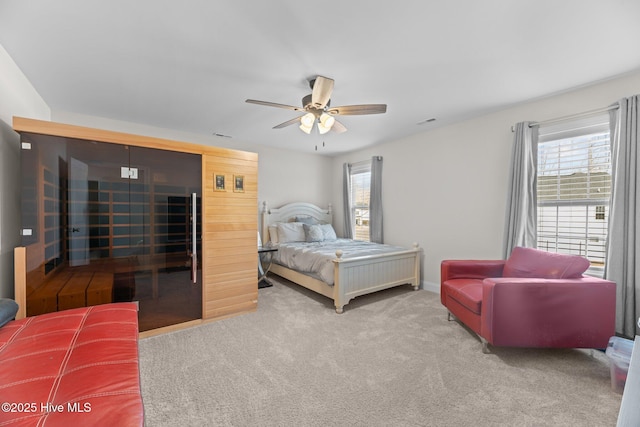 bedroom with ceiling fan, multiple windows, visible vents, and carpet flooring