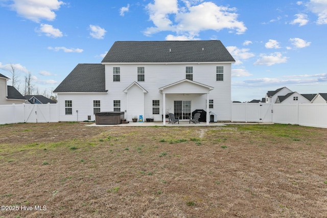 back of house with a patio area, a hot tub, a gate, and a yard