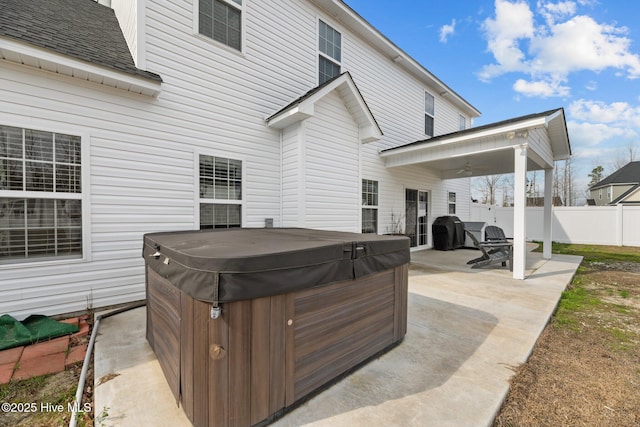 view of patio with fence, a grill, and a hot tub