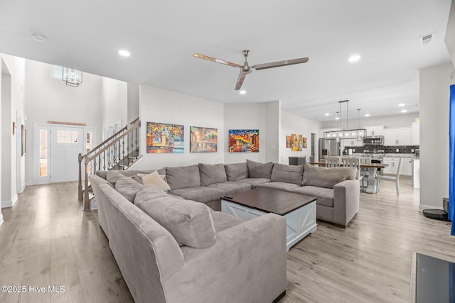 living area featuring recessed lighting, visible vents, light wood-style flooring, stairway, and a ceiling fan