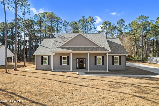 view of front of home featuring a front yard, a porch, and roof with shingles