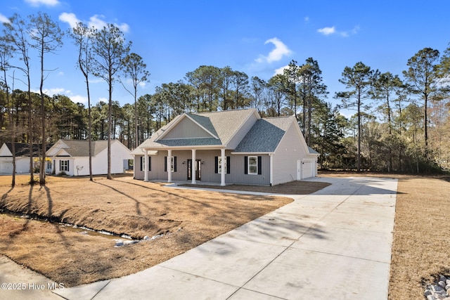 195 Boundary Loop Rd NW, Calabash, NC 28467 - view of front of house with a porch, driveway, roof with shingles, and view of wooded area