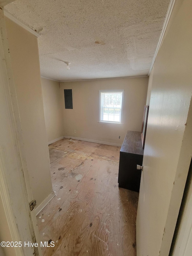 unfurnished room with a textured ceiling, baseboards, electric panel, and crown molding