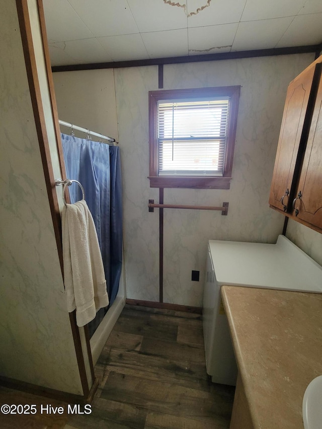 bathroom featuring washer / dryer, a shower with curtain, and wood finished floors