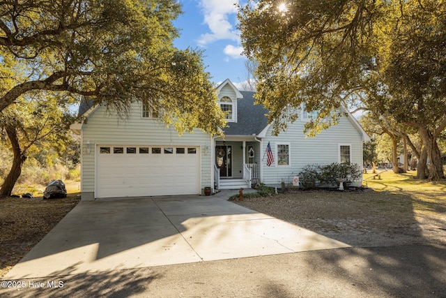 traditional home featuring a garage, concrete driveway, and a shingled roof