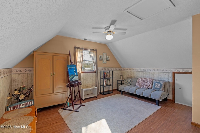 122 Charlie Lewis Ln, Beaufort, NC 28516 - living area with a wainscoted wall, a textured ceiling, wood finished floors, a ceiling fan, and lofted ceiling
