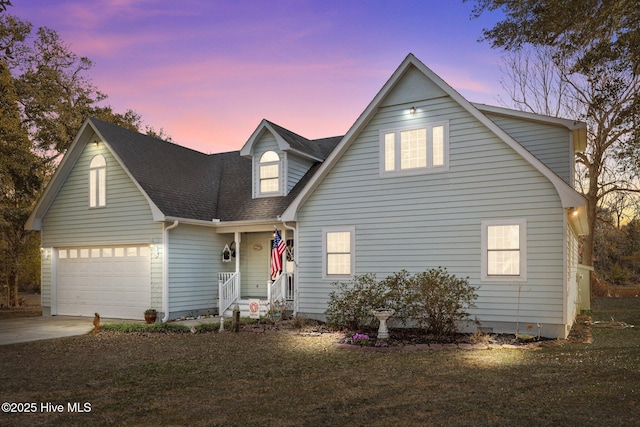 traditional-style house featuring a garage, a shingled roof, a front lawn, and concrete driveway