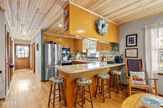 122 Charlie Lewis Ln, Beaufort, NC 28516 - kitchen with stainless steel appliances, a sink, wood ceiling, light countertops, and a peninsula