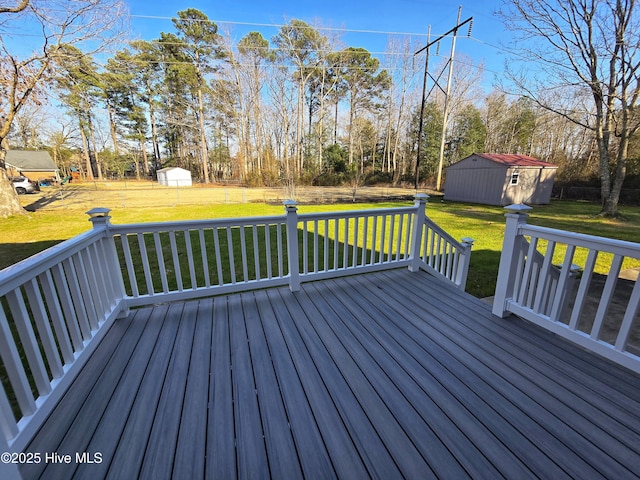 wooden deck featuring a storage shed, a lawn, and an outbuilding