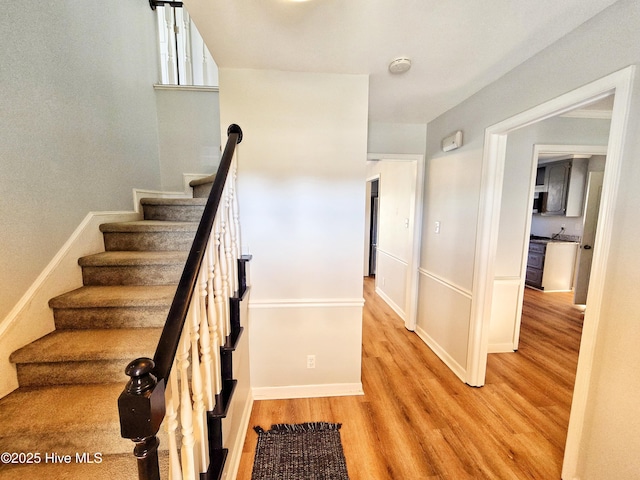 stairway with baseboards and wood finished floors