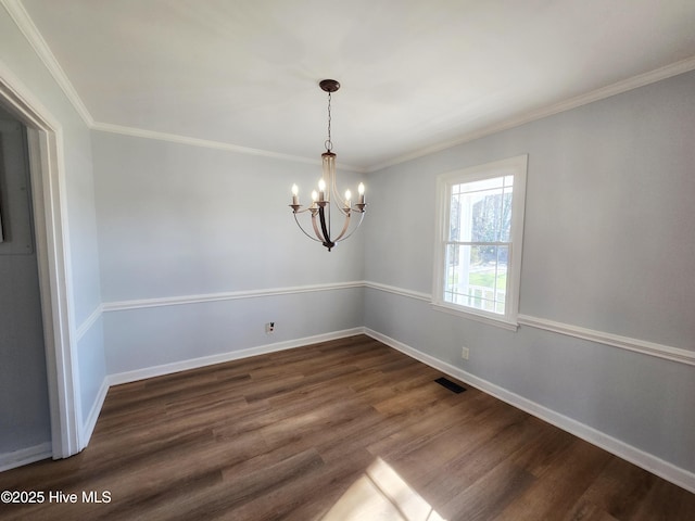 empty room with baseboards, a notable chandelier, dark wood-style floors, and ornamental molding