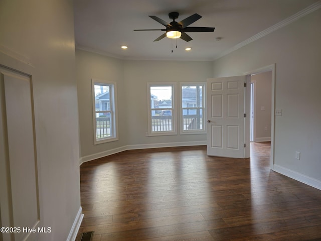 empty room featuring baseboards, dark wood finished floors, and ornamental molding