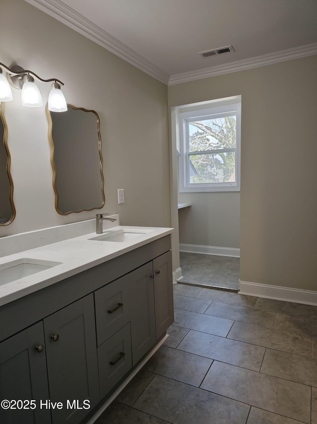 bathroom with visible vents, ornamental molding, a sink, double vanity, and baseboards