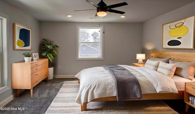 bedroom featuring baseboards, dark carpet, and ceiling fan