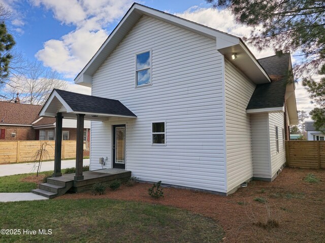 view of front of property featuring fence and roof with shingles