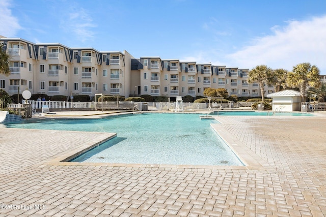 community pool featuring a patio and fence