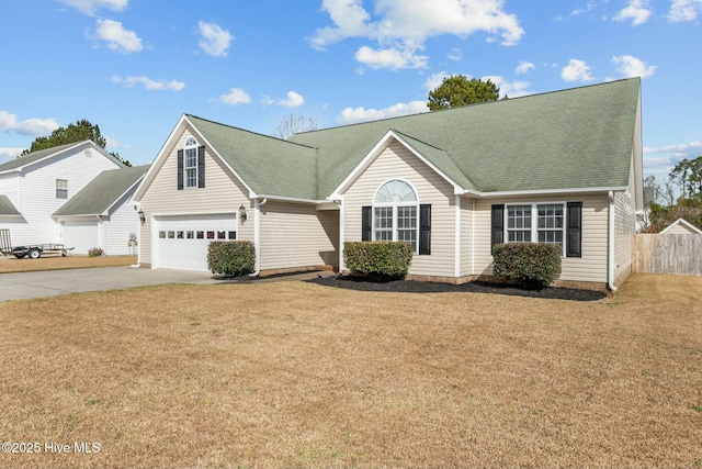 view of front facade featuring concrete driveway, a shingled roof, a front yard, and fence