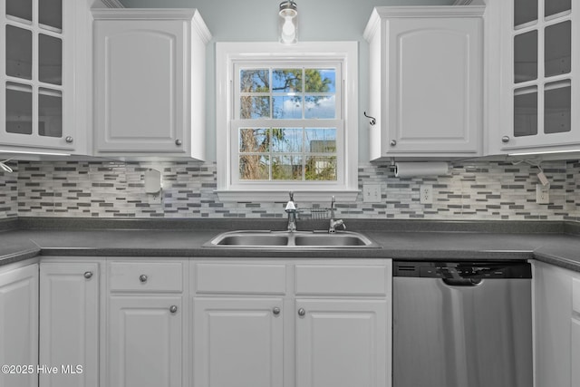 kitchen with dishwasher, dark countertops, a sink, and white cabinetry